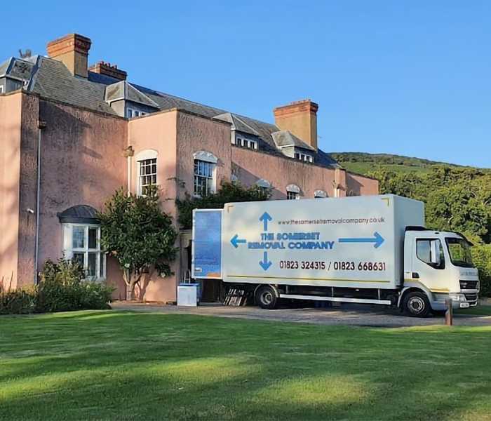 The Somerset Removal Company long wheel base lorry removing goods from a manor house